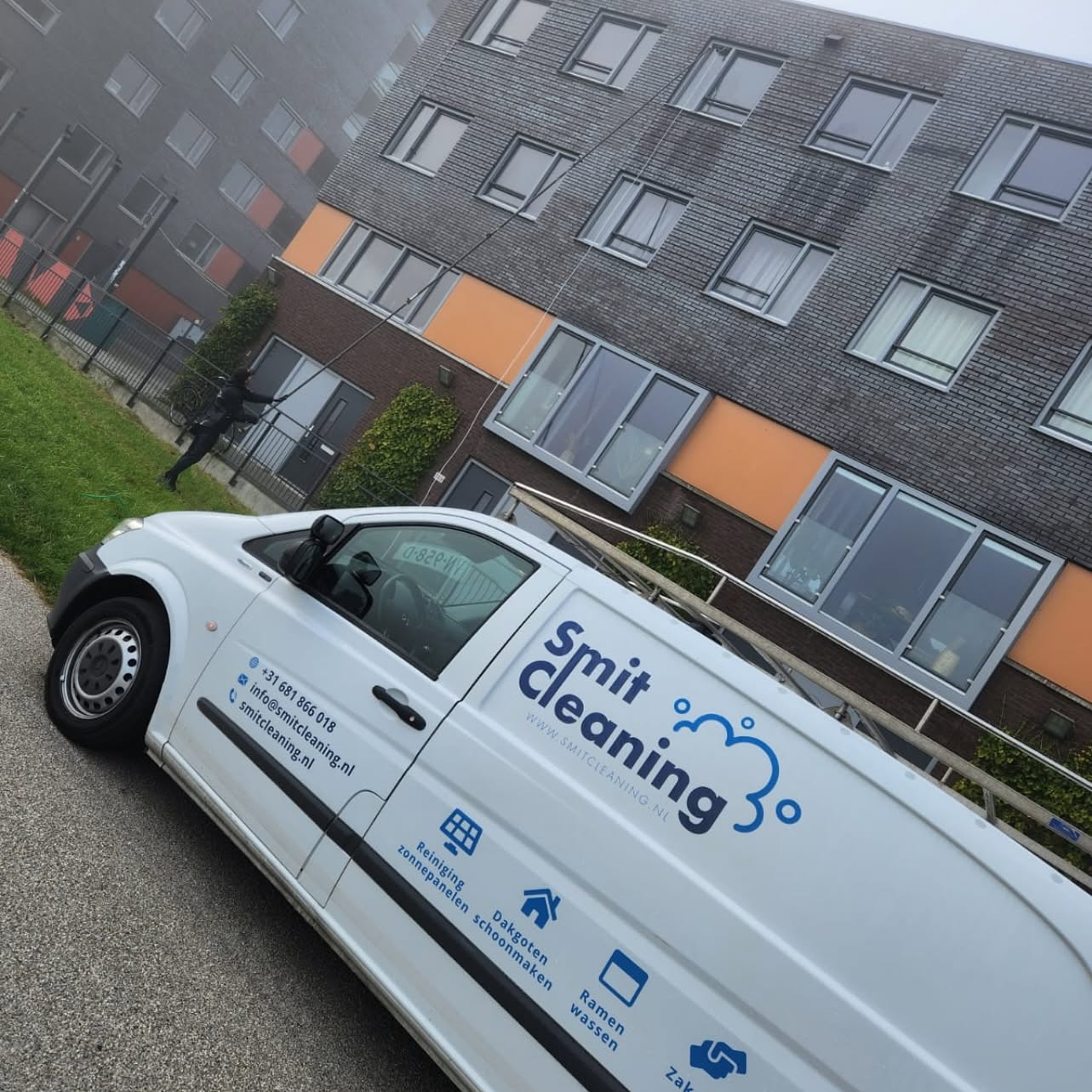 Bestelbus van Smit Cleaning bij een bedrijfspand met glazen gevel